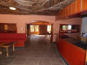 ein Wohnzimmer mit roten Bänken und einer Bar in der Unterkunft Seasons Elementaita Country Lodge in Nakuru