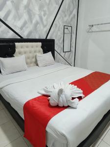 a bed with a white towel on a red blanket at Dnaiko Syariah Hotel in Bukittinggi +38 photos
