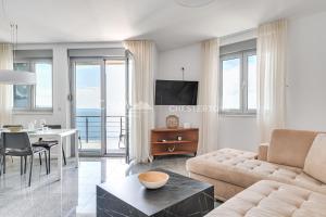 a living room with a couch and a table at Blue Seacliff Luxe in Komoševina