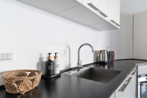 a kitchen with a sink and a black counter top at Blue Seacliff Luxe in Komoševina