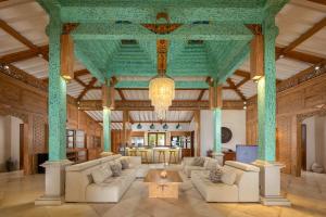 a living room with couches and a chandelier at Eliana Resort And Spa in Nembrala
