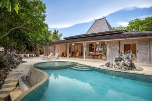 a swimming pool in front of a house at Eliana Resort And Spa in Nembrala