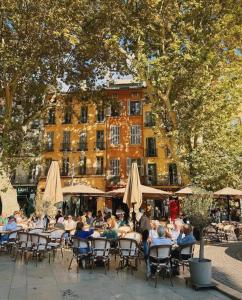 a group of people sitting at tables with umbrellas at Villa Augustine - Maison classée 5 étoiles avec piscine à Aix en Provence in Aix-en-Provence