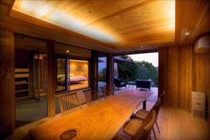 a dining room with a wooden table and chairs at Kisara Oneness in Toba
