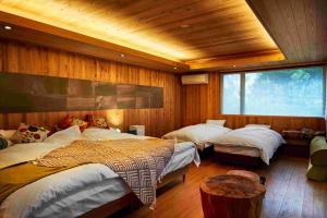 a bedroom with three beds in a room with wooden walls at Kisara Oneness in Toba +27 photos