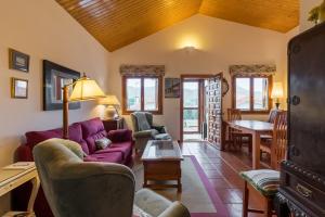 a living room with a purple couch and chairs at Las Camelias in Argoños