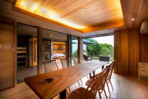 a dining room with a long wooden table and chairs at Kisara Oneness in Toba