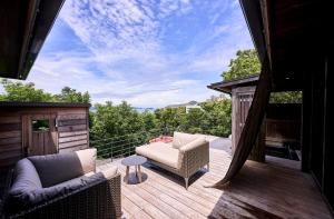 a patio with a couch and chairs on a deck at Kisara Oneness in Toba