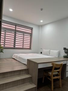 a bedroom with a bed and a desk with a chair at SQUIRRELHOME District8 in Ho Chi Minh City