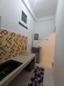 a kitchen with a sink and a counter top at Dnaiko Syariah Hotel in Bukittinggi