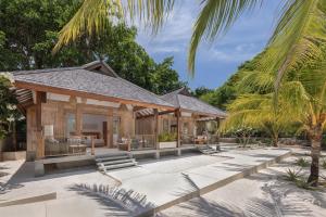 an outdoor patio of a villa with palm trees at Eliana Resort And Spa in Nembrala