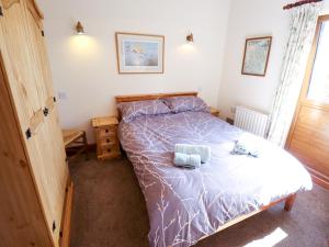 a bedroom with a bed with a purple comforter at Kingfisher in Louth