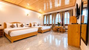 a hotel room with two beds and a table at Sumitel Sonam Lachung in Lachung