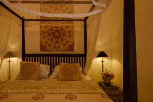 a bedroom with a canopy bed with two lamps at Treasure Rock in Kirinda +66 photos