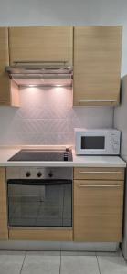 a kitchen with a stove and a microwave at Fare Iki in Papeete