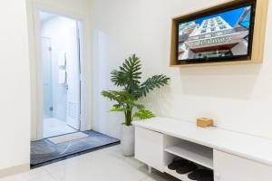 a living room with a tv on a wall at Palmier Hotel - Art House Da Nang in Danang +71 photos