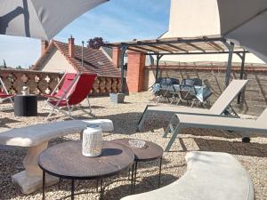 a patio with chairs and tables and an umbrella at Appartement de cachet de 63m2 in Moulins