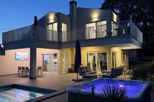 a large house with a swimming pool in front of it at Casa Belladonna by Briskva in Višnjan
