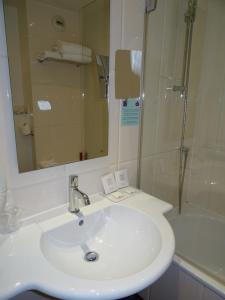 a bathroom with a white sink and a shower at Le Marceau Bastille in Paris