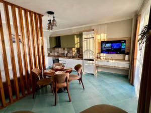 a living room with a table and chairs and a television at Eri Apartments 2 in Shëngjin