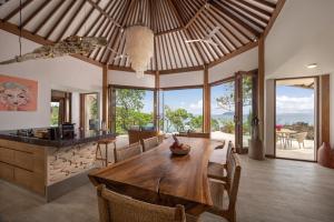 a kitchen and dining room with a wooden table and chairs at Eliana Resort And Spa in Nembrala