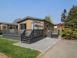 a log cabin with a large porch and a deck at Tulip in Leominster