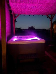 a pink bathtub with a purple lighting in a house at Chalet Des Aigrettes- Jacuzzi privatif in Chassey-lès-Montbozon