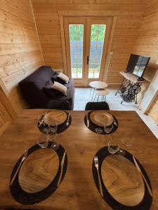 a room with a table with wine glasses on it at Chalet Des Aigrettes- Jacuzzi privatif in Chassey-lès-Montbozon +1 photo