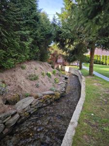 a stone retaining wall in a yard with trees at Agroturystyka Pod Małą Górą in Łopuszna