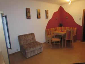 a living room with a table and a chair and a couch at Hutmannhof-Ferienwohnungen in Dellach