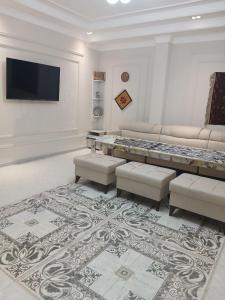 a living room with couches and a flat screen tv at Xonobod НОТЕL in Khiva
