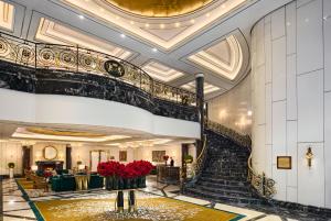 a spiral staircase in a hotel lobby with red flowers at Breidenbacher Hof, Best Hotel of the Year 2026 - Die 101 Besten in Düsseldorf +52 photos