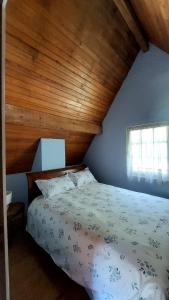 a bedroom with a bed with a wooden ceiling at Chalet chateau verdun in Château-Verdun +2 photos