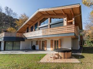 a house with a deck and a grill in the yard at La Parenthèse du Goûter - by Care Concierge in Les Houches