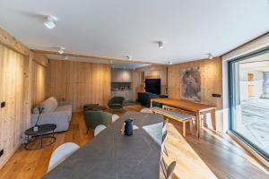 a living room with wooden walls and a large window at La Parenthèse du Goûter - by Care Concierge in Les Houches