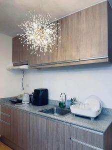 a kitchen counter with a sink and a chandelier at Very Cozy Condo Davao in Davao City