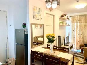 a kitchen and living room with a table and a refrigerator at Very Cozy Condo Davao in Davao City