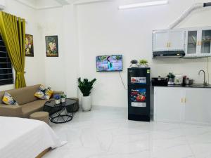 a living room with a couch and a kitchen at Harmony Apartment in Hanoi