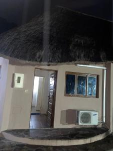 a model of a small house with a roof at The Huts in Vila Praia Do Bilene