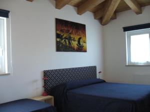 a bedroom with two beds and a picture on the wall at alla Gledizia in Udine
