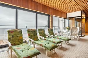 a row of chairs in a room with windows at Nordseeblick in Bremerhaven