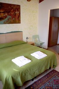a bedroom with a green bed with towels on it at alla Gledizia in Udine