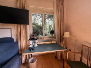 a bedroom with a bed and a desk with a window at Lautertal Panorama-Suite - Kingsize-Bett & Badewanne & Dusche - Raucherbereich vor überdachten Terrasse - Rosengarten - Parkplätze 15m entfernt- Naturschutzgebiet vor Haustüre - sehr ruhige Gegend - Self-Checkin - 45qm2 in Blaustein