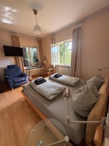 a room with two beds and a couch in it at Lautertal Panorama-Suite - Kingsize-Bett & Badewanne & Dusche - Raucherbereich vor überdachten Terrasse - Rosengarten - Parkplätze 15m entfernt- Naturschutzgebiet vor Haustüre - sehr ruhige Gegend - Self-Checkin - 45qm2 in Blaustein