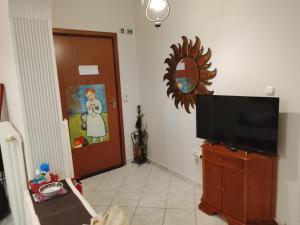 a living room with a flat screen tv and a mirror at Savelona's Guest Appartment in Agrinio