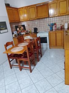 a kitchen with a table and some chairs and a table and a tablektop at Savelona's Guest Appartment in Agrinio +2 photos