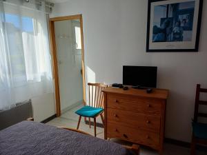 a bedroom with a bed and a television on a dresser at maison 6 personnes in Locquirec