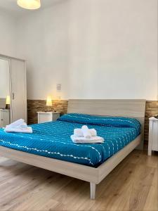 a bed with blue sheets and white towels on it at ZenZone House in La Spezia