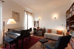 ein Wohnzimmer mit einem Klavier und einem Schreibtisch in der Unterkunft Grand Piano Apartment in Florenz