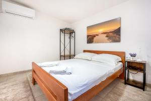 a bedroom with a large bed with white sheets at Apartments Sunce in Neum